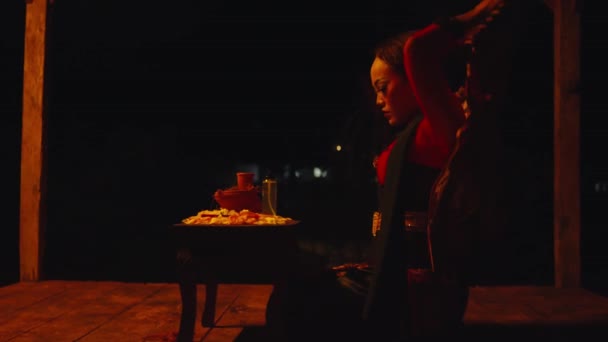 一个女人晚上在一间可怕的小屋里从礼仪桌上取下口红 — 图库视频影像