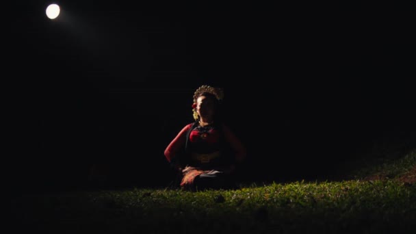 Aasialainen Nainen Istuu Vihreällä Ruoholla Tanssiessaan Käsillään Punaisella Huivilla Metsässä — kuvapankkivideo