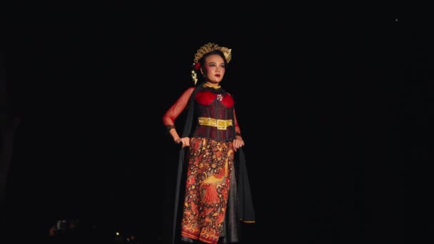 在漆黑的夜晚 一个身穿蜡染服装和黑色围巾的亚洲女人自信地站在那里 — 图库视频影像