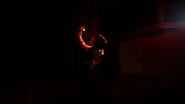 the silhouette of a female dancer holding jewelry that looks like a reflection reflecting in the dim light at night