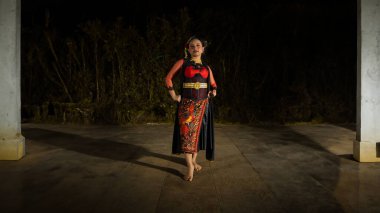 Endonezyalı bir dansçı coşkuyla bakar ve geceleri dans etmek için cesaretini gösterir.