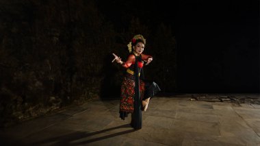 Sundanlı bir dansçı güzel, kırmızı bir kostüm giyer ve geceleri tutkulu bir ifadeyle dans eder.