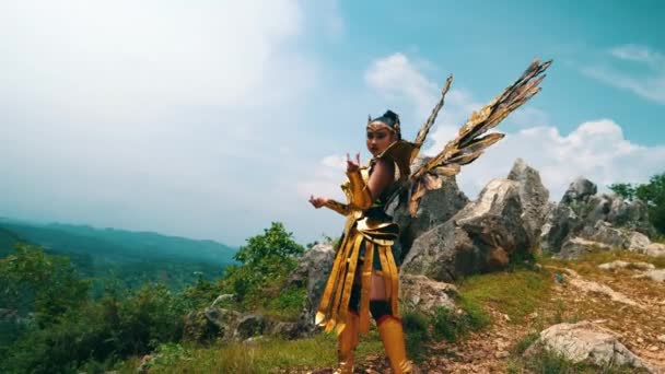 Female Warrior Golden Costume Wings Standing Rocky Mountain Blue Sky — Stock Video