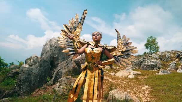 Een Vrouwelijke Krijger Een Gouden Kostuum Vleugels Staand Een Rotsachtige — Stockvideo