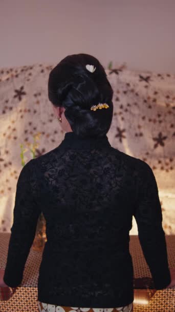 面容端庄的女人 身穿黑色花边上衣 背对着花纹背景 — 图库视频影像
