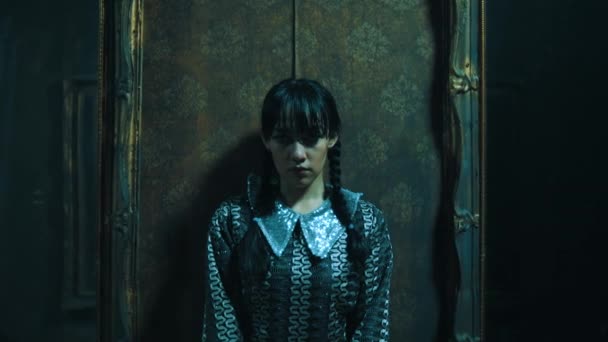 身穿老式衣服的神秘女孩站在一间光线昏暗 令人生畏的房间里 房间里装饰着鬼屋中的古董 — 图库视频影像