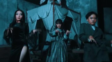 Perili evin içinde yoğun ifadeler ve dinamik pozlarla dramatik bir dans sahnesi sergileyen bir grup aktör.