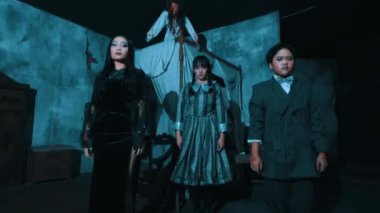 Perili evin içinde siyah kostümlü aktörlerle dramatik bir dans gösterisi.