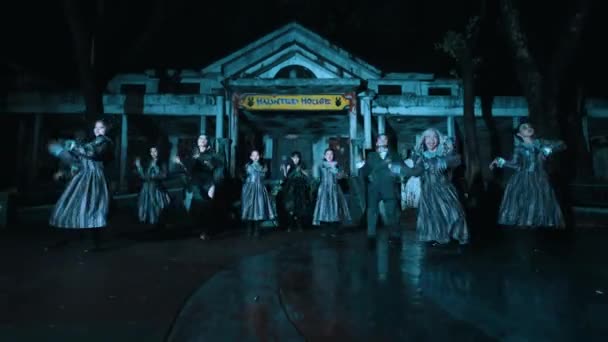 一群身着古装的人夜晚在一座古色古香的大楼前跳着舞 上面有醒目的标志和恐怖的场面 — 图库视频影像