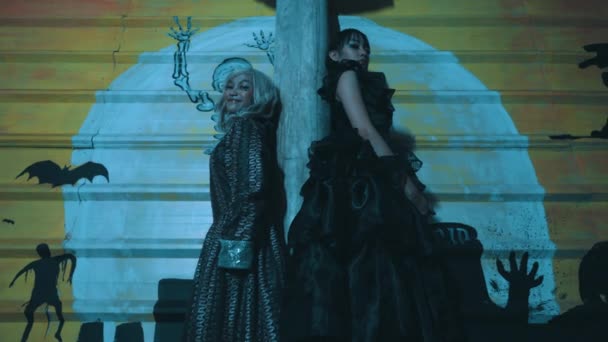Dvě Ženy Gotických Kostýmech Pózující Strašidelném Pozadí Halloweenskými Siluetami Temné — Stock video