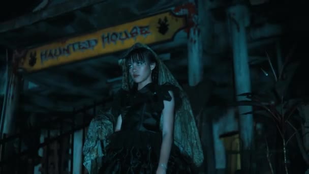 Hátborzongató Lány Gótikus Ruhában Áll Egy Kísértetház Tábla Alatt Éjszaka — Stock videók