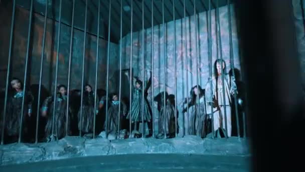 轮廓鲜明的人影在监狱后面以凉爽的蓝调舞动 在漆黑的夜晚营造出一种神秘而怪异的气氛 — 图库视频影像
