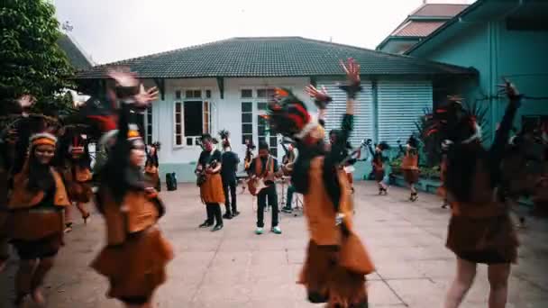 建物の前で演奏する伝統的なダンサーは 昼間の文化遺産やお祭りの雰囲気を示しています — ストック動画