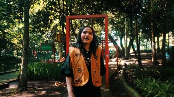 Стильна Жінка Позує Парку Червоною Рамкою Оточена Пишною Зеленню Під — стокове відео