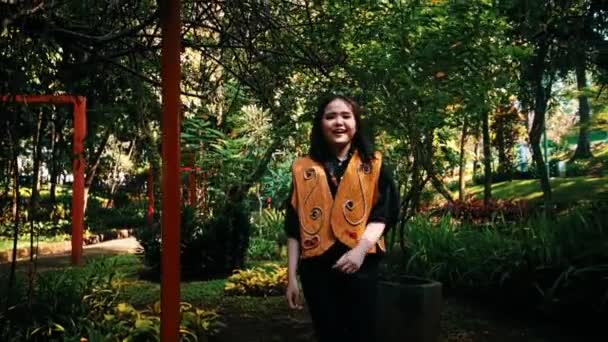 Mujer Sonriente Parque Con Árboles Verdes Pilares Rojos Estilo Casual — Vídeo de stock