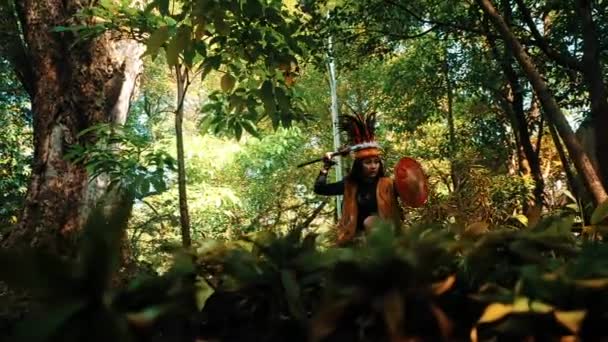 朝の緑豊かな森でドラムを演奏する伝統的な服装の先住民 — ストック動画