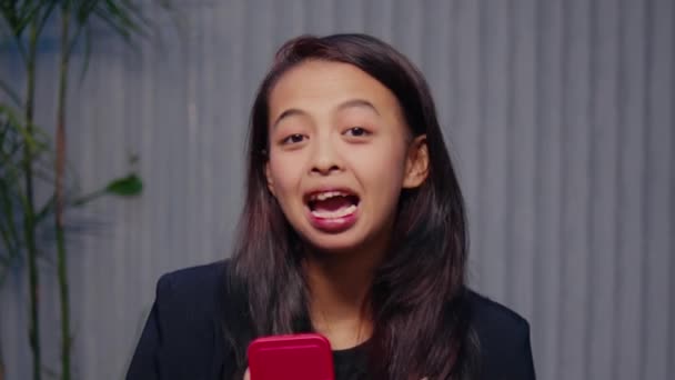 Lekfull Ung Kvinna Sticker Tungan Medan Håller Smart Telefon Uttrycker — Stockvideo