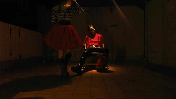 身穿红衫的男人坐在喜怒无常的灯光下 墙上笼罩着戏剧性的阴影 — 图库视频影像