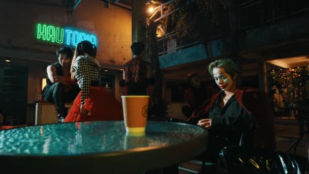 Jovens Elegantes Sentados Café Urbano Mal Iluminado Com Sinais Néon — Vídeo de Stock