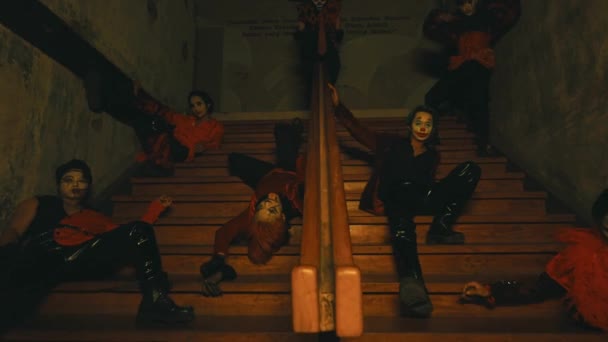 一群化着令人毛骨悚然的小丑 晚上坐在一幢闹鬼的大楼的楼梯上 摆姿势 — 图库视频影像