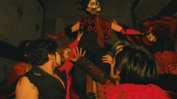 一群化着令人毛骨悚然的小丑 晚上坐在一幢闹鬼的大楼的楼梯上 摆姿势 — 图库视频影像