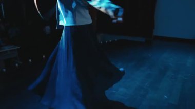 Geleneksel kostümlü zarif flamenko dansçısı loş bir odada performans sergiliyor, gece boyunca tutku ve sanatsal ifadeler sergiliyor.