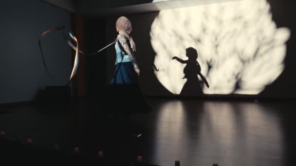 Silhueta Uma Jovem Dançando Com Arco Lançando Uma Grande Sombra — Vídeo de Stock