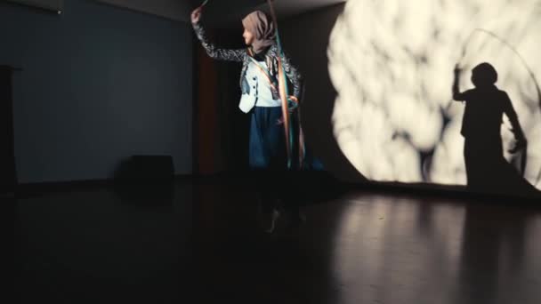 一个年轻姑娘带着圈圈跳舞的轮廓 在夜半昏暗的房间里 给墙上投下了一个巨大的阴影 — 图库视频影像