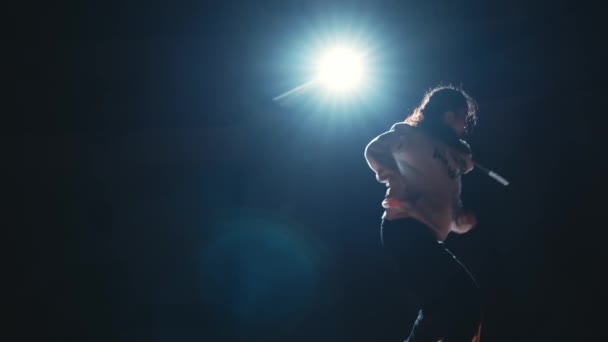 Silhouette Einer Person Unter Einem Scheinwerfer Auf Einer Dunklen Bühne — Stockvideo