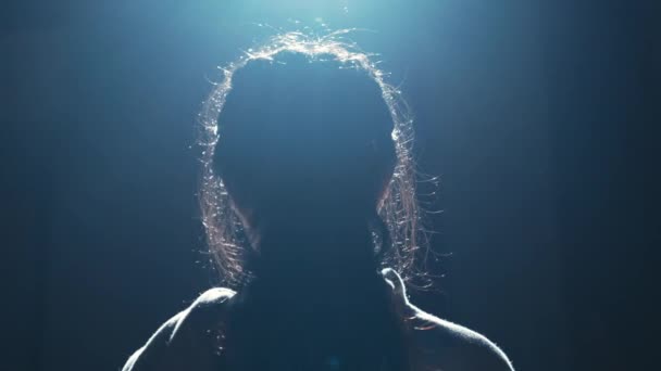 Silhouette Una Donna Uno Sfondo Scuro Con Retroilluminazione Drammatica Durante — Video Stock