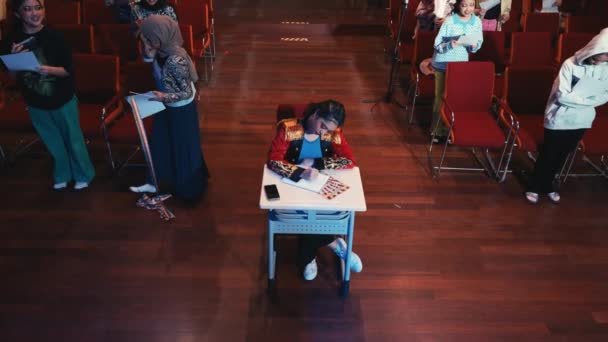 Bambino Seduto Alla Scrivania Auditorium Con Pubblico Attento Sullo Sfondo — Video Stock