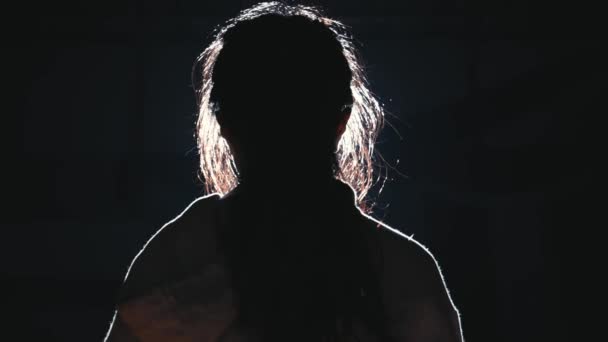 Silhouet Van Een Vrouw Met Velglicht Tegen Een Donkere Achtergrond — Stockvideo
