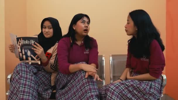Tres Mujeres Jóvenes Conversando Una Sosteniendo Una Revista Ambiente Interior — Vídeos de Stock