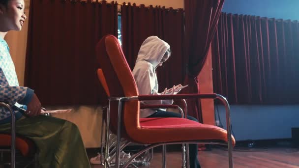 Женщина Толстовке Выглядит Смущенной Падает Посреди Спектакля Полного Зрителей Театре — стоковое видео