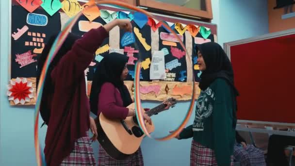 Trzy Kobiety Klasie Jedna Gra Gitarze Kolorowymi Dekoracjami Papierowymi Ścianie — Wideo stockowe