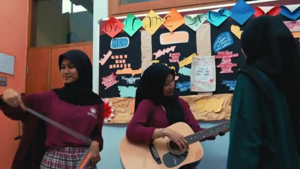 Três Mulheres Ambiente Sala Aula Uma Tocando Guitarra Com Decorações — Vídeo de Stock