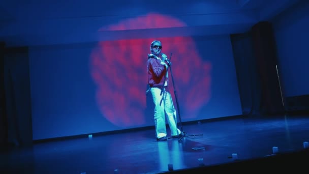극적인 파란색 조명과 빨간색 추상적인 배경으로 무대에서 연주자 — 비디오