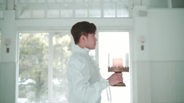 Garson gün ışığında, modern bir restoranda tepside içki servisi yapıyor.