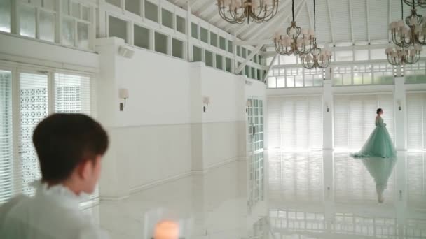 Elegant Woman Flowing Dress Walking Luxurious Bright Room Chandeliers Observed — Stock Video