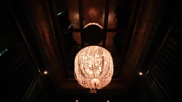 Elegancki Żyrandol Ciepłym Oświetleniem Wiszącym Ciemnym Suficie Tworząc Przytulną Luksusową — Wideo stockowe