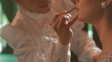 Klasik stil sahibi bir çift. Erkek, kadının ruj sürüşünü izliyor. Gündüz vakti romantik ve zarif bir atmosfer.