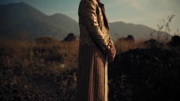 Άνδρας Κομψό Φόρεμα Στέκεται Ένα Πεδίο Στο Ηλιοβασίλεμα Βουνά Στο — Αρχείο Βίντεο