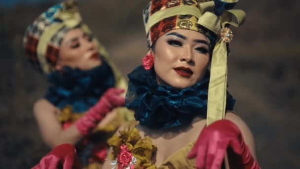 デイライト中の前景パフォーマーに焦点を当てた 精巧な衣装とメイクで伝統的なアジアのダンサー — ストック動画