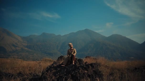 一个孤独的徒步旅行者躺在一块岩石上 岩石上的背景是清澈的蓝天 山清水秀 — 图库视频影像