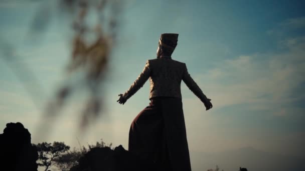 昼間の明るい空に対する伝統的な服装の人物のシルエット — ストック動画