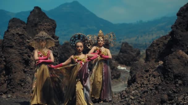 朝のバックグラウンドで山々と火山の風景で演奏するオーナイトコスチュームの伝統的なバリのダンサー — ストック動画