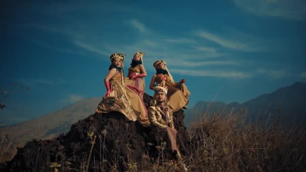 Quatro Mulheres Vestidos Fluidos Coroas Sentadas Afloramento Rochoso Com Pano — Vídeo de Stock