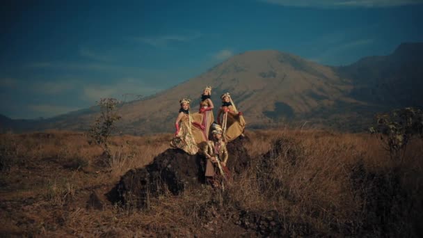 伝統的な部族の女性は 日光の間に背景の山で険しい風景に沿って歩いています — ストック動画