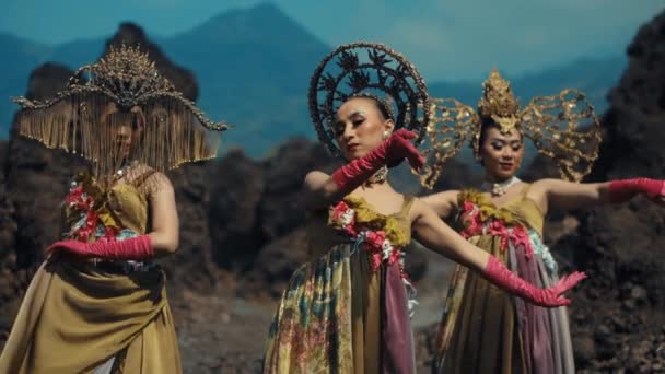 伝統的な衣装の3人の女性が踊り 午前中に山岳地帯を背景に — ストック動画