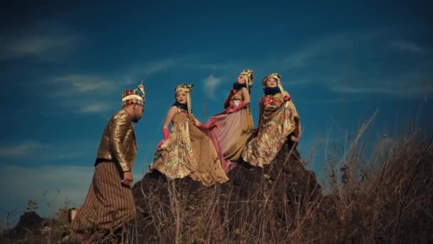 Three People Elaborate Costumes Posing Rocky Landscape Dramatic Sky Daylight — Stock Video